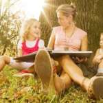 baby nurse or nanny reading a book to two little kids