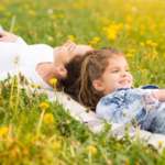 Child Gazing At The Clouds With Her Nanny