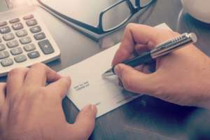 Homeowner Writing a Staff Member's Pay Check