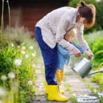 Summer nanny in the garden with her child