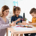 Nanny helping children draw