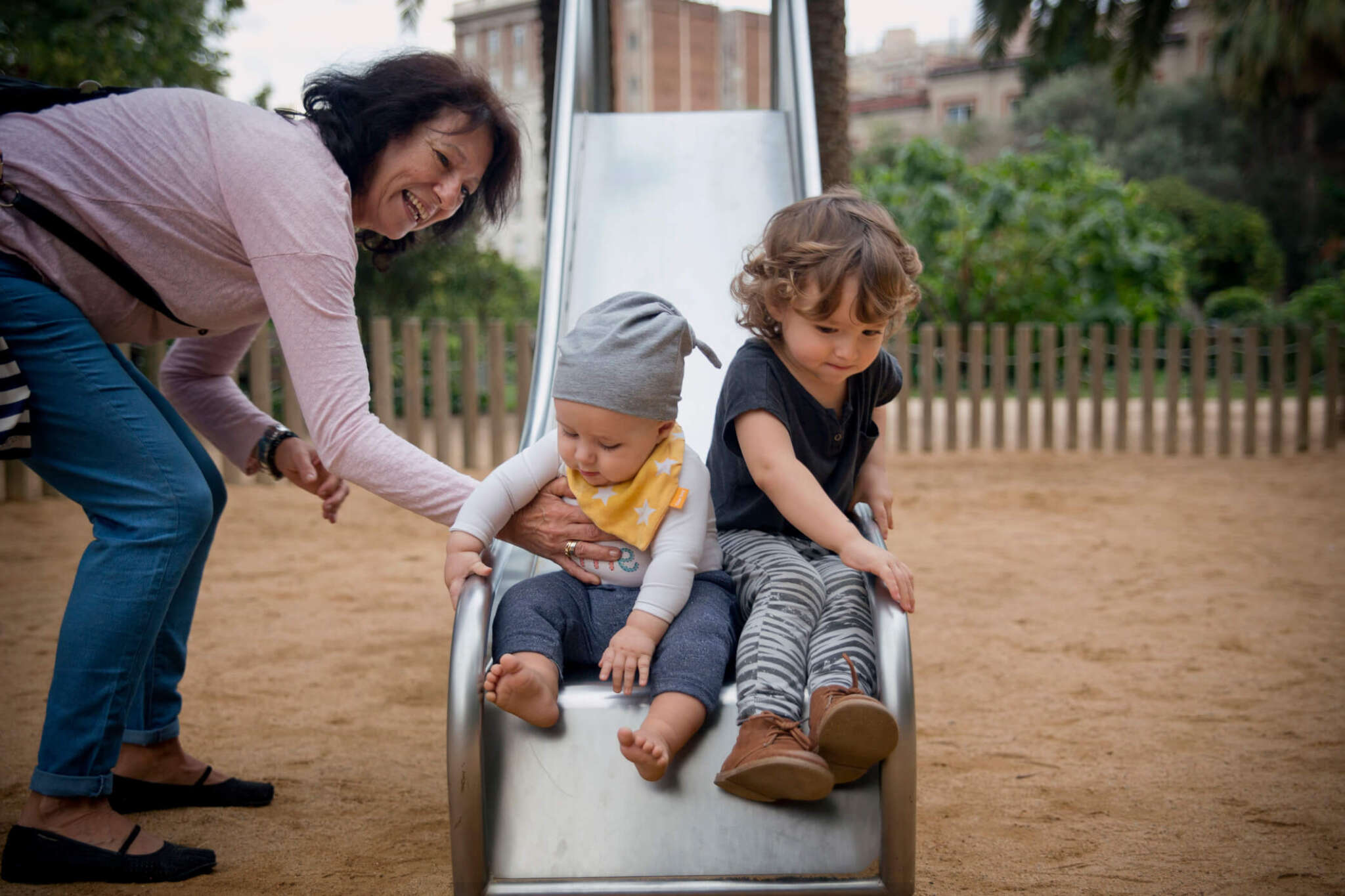 summer nanny with children on park slide