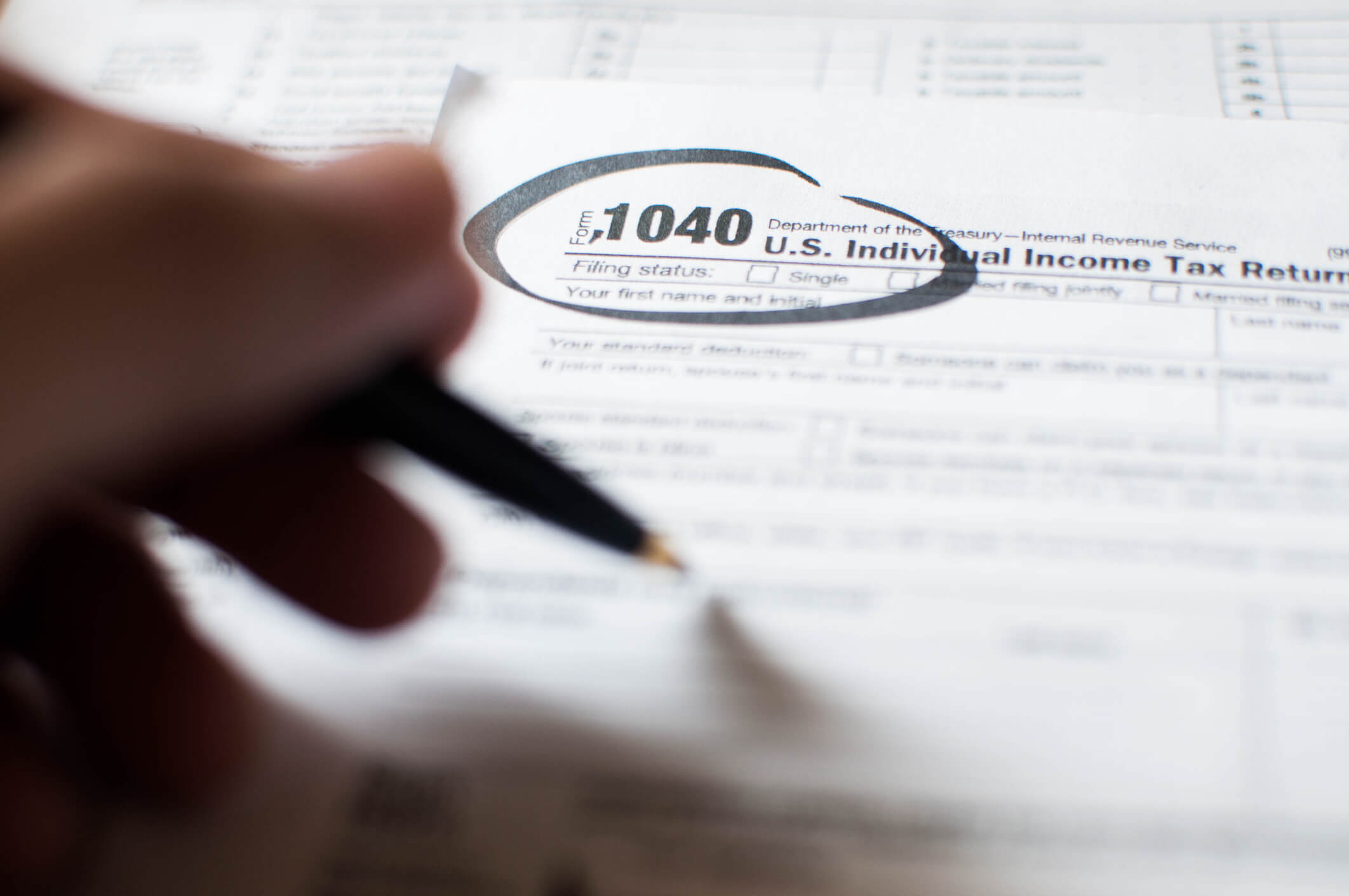 A young person writing on a tax document