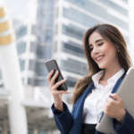 Smiling young business woman with smart phone