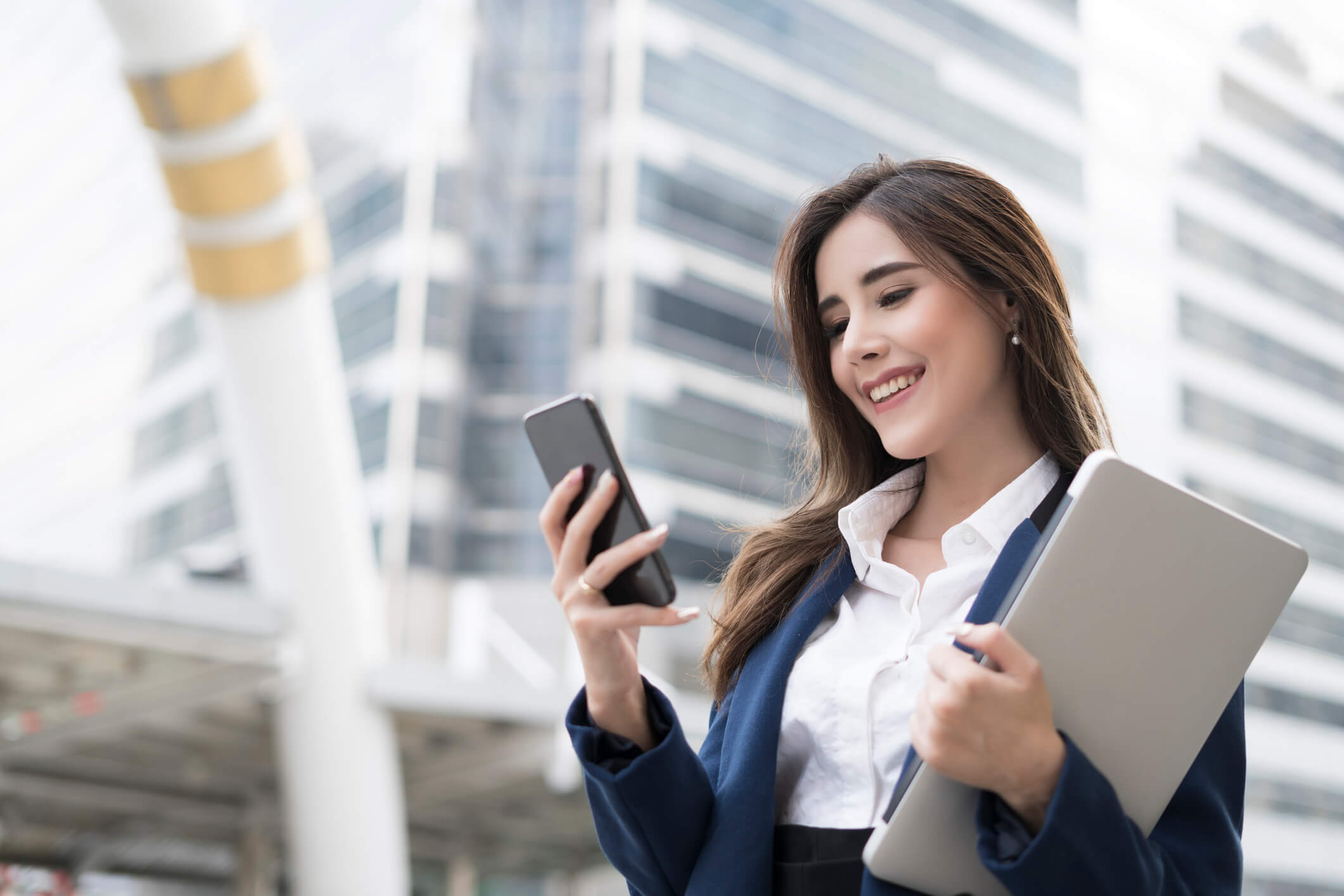 Smiling young business woman with smart phone