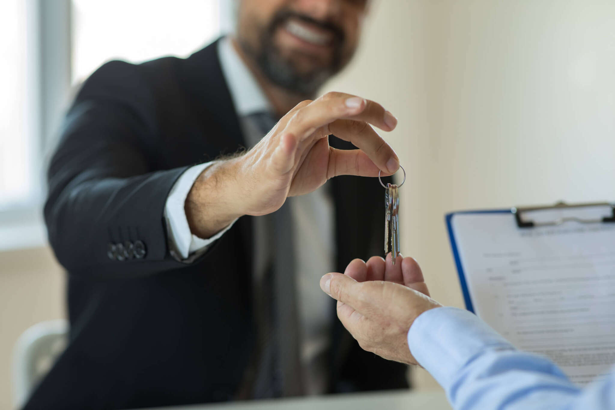 Property owner hand giving keys to estate manager