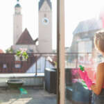 Housekeeper cleaning a window