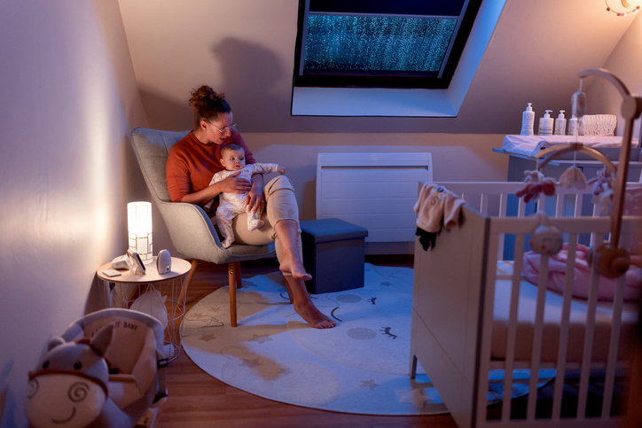 Night nurse comforting baby in the nursery