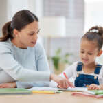 Young girl learning with a nanny homeschool teacher one-on-one at home