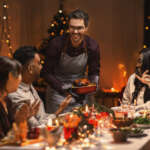 A private chef serves a festive holiday meal to a group celebrating seasonal traditions together.
